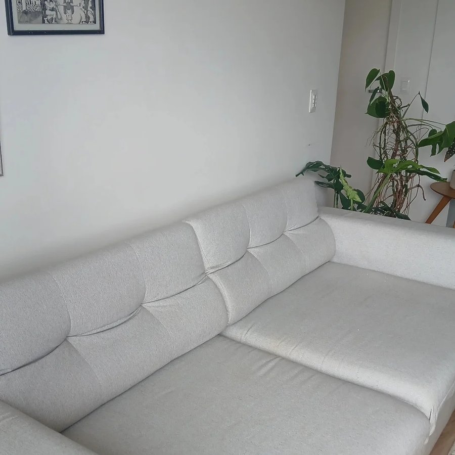 Sofá cinza claro em sala de estar higienizado